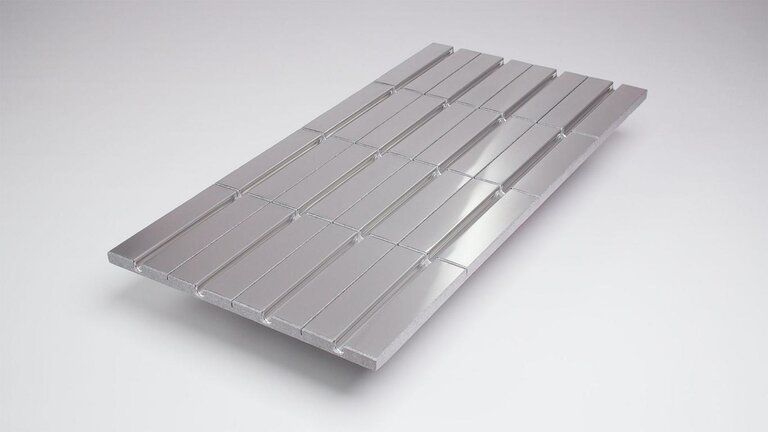 Klimamodul mit regelmäßig angeordneten, rechteckigen Vertiefungen auf einer glatten, reflektierenden Oberfläche.